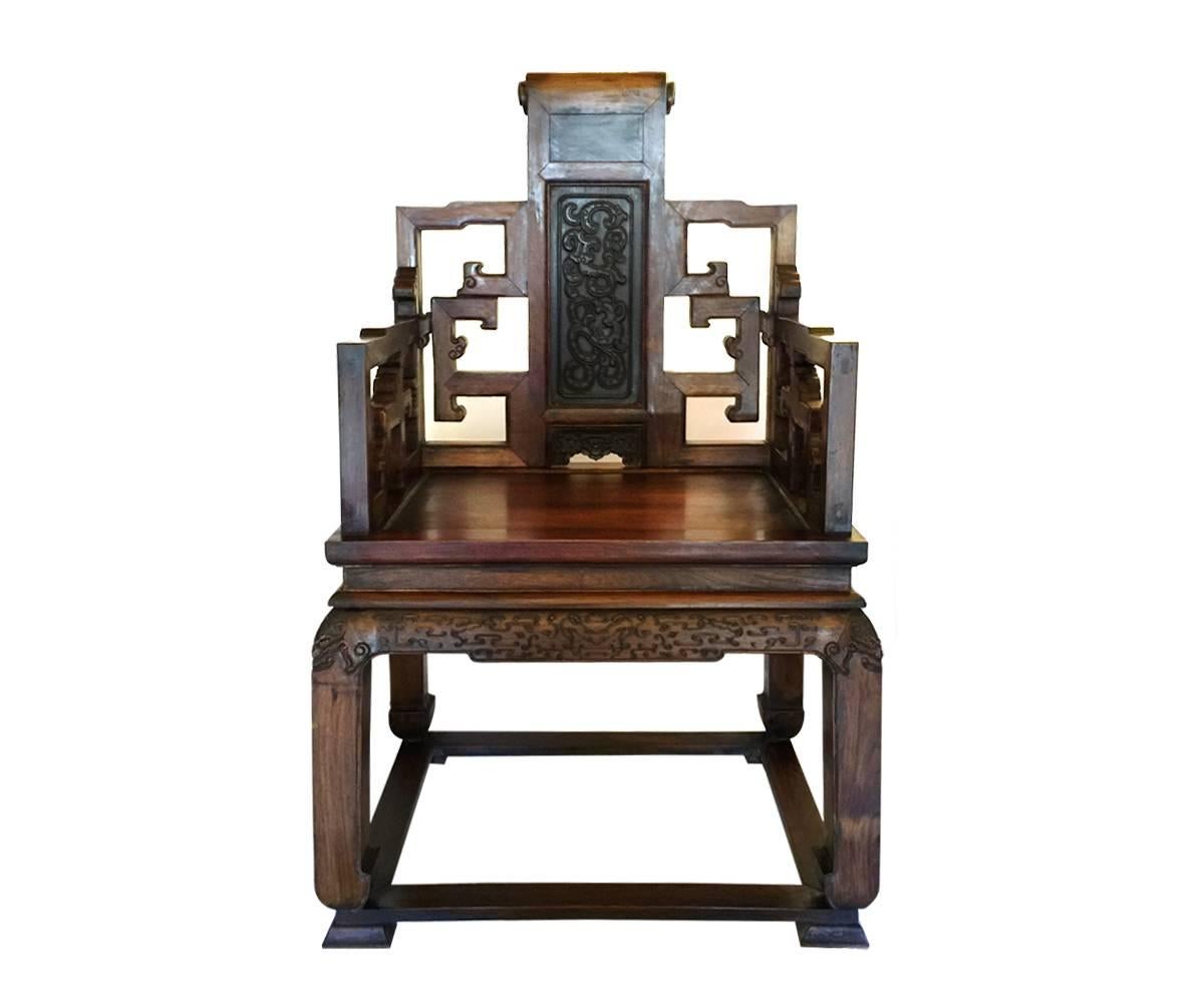 We proudly offer two Chinese carved huanghuali armchairs for the discriminating buyer.  Each chair is of rectilinear openwork form with the splats set with zitan panels of archaistic chilong design. They also have additional carving along the aprons