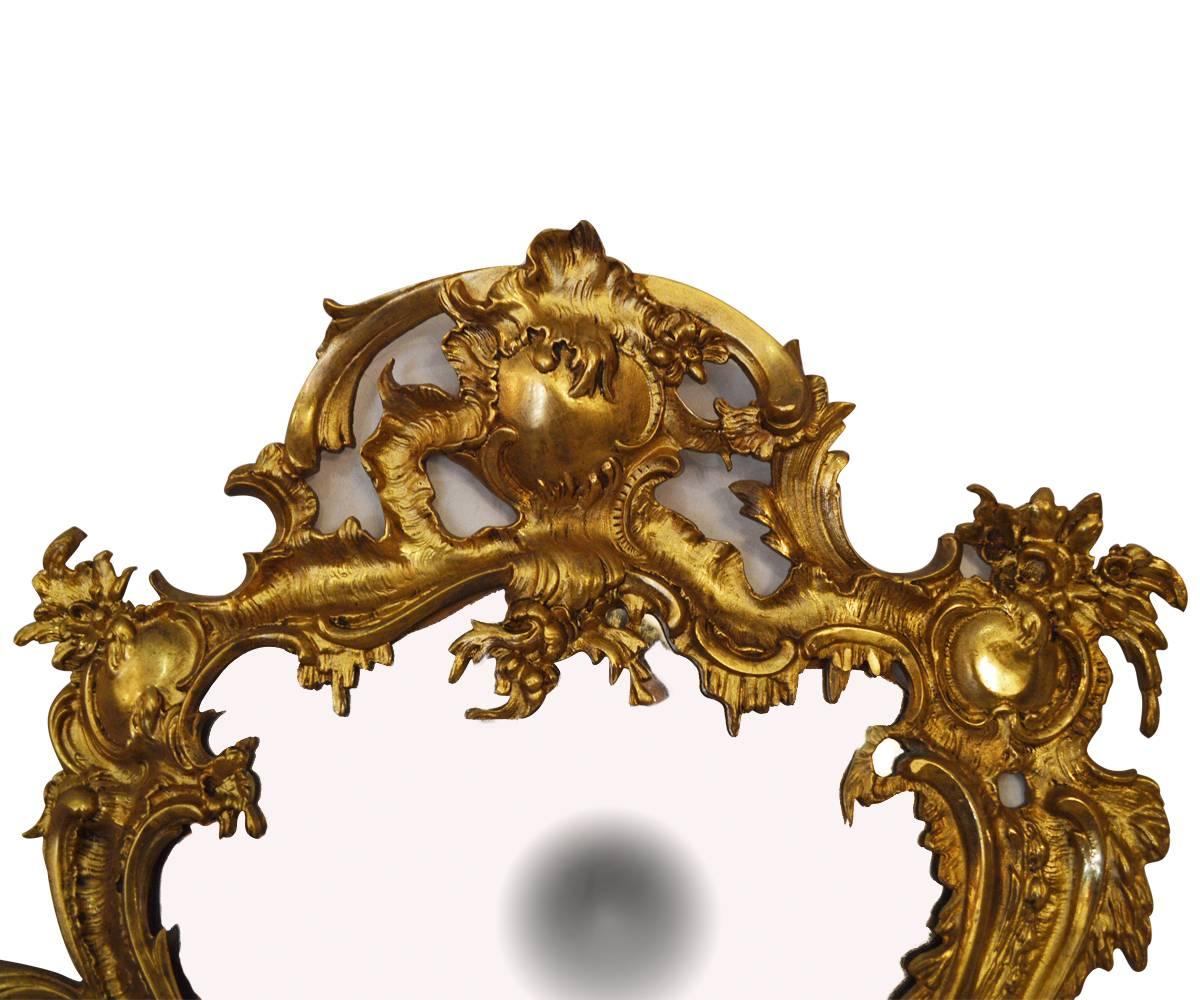 This is a fabulous pair of gilt bronze mirrors in the Louis XV style. The workmanship is excellent and the gilding is exceptional. This pair will grace any room.