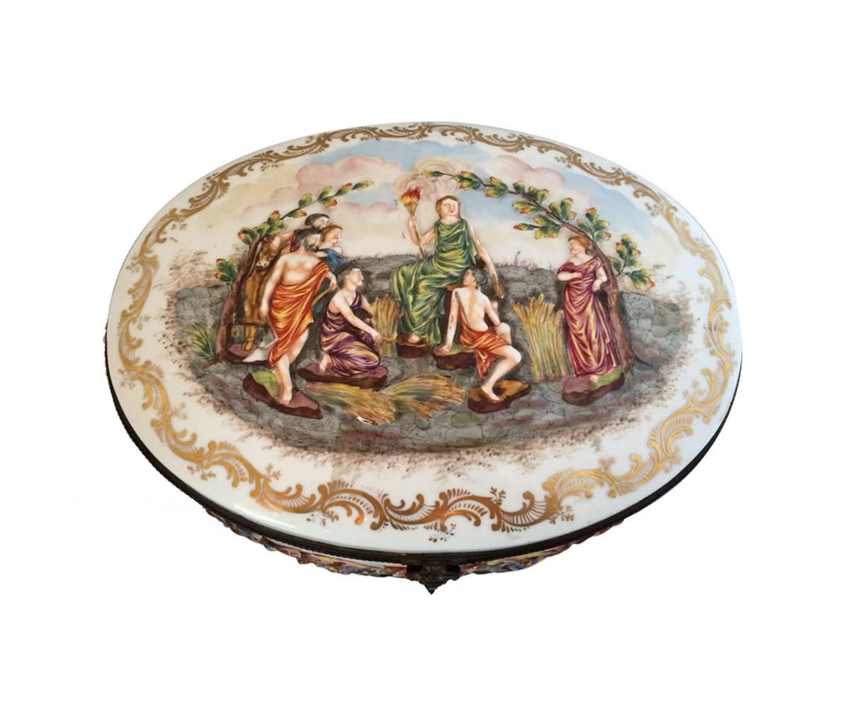 This is an old Capodimonte box, circa 1920, with bronze trim and hand painting on the embossed art.