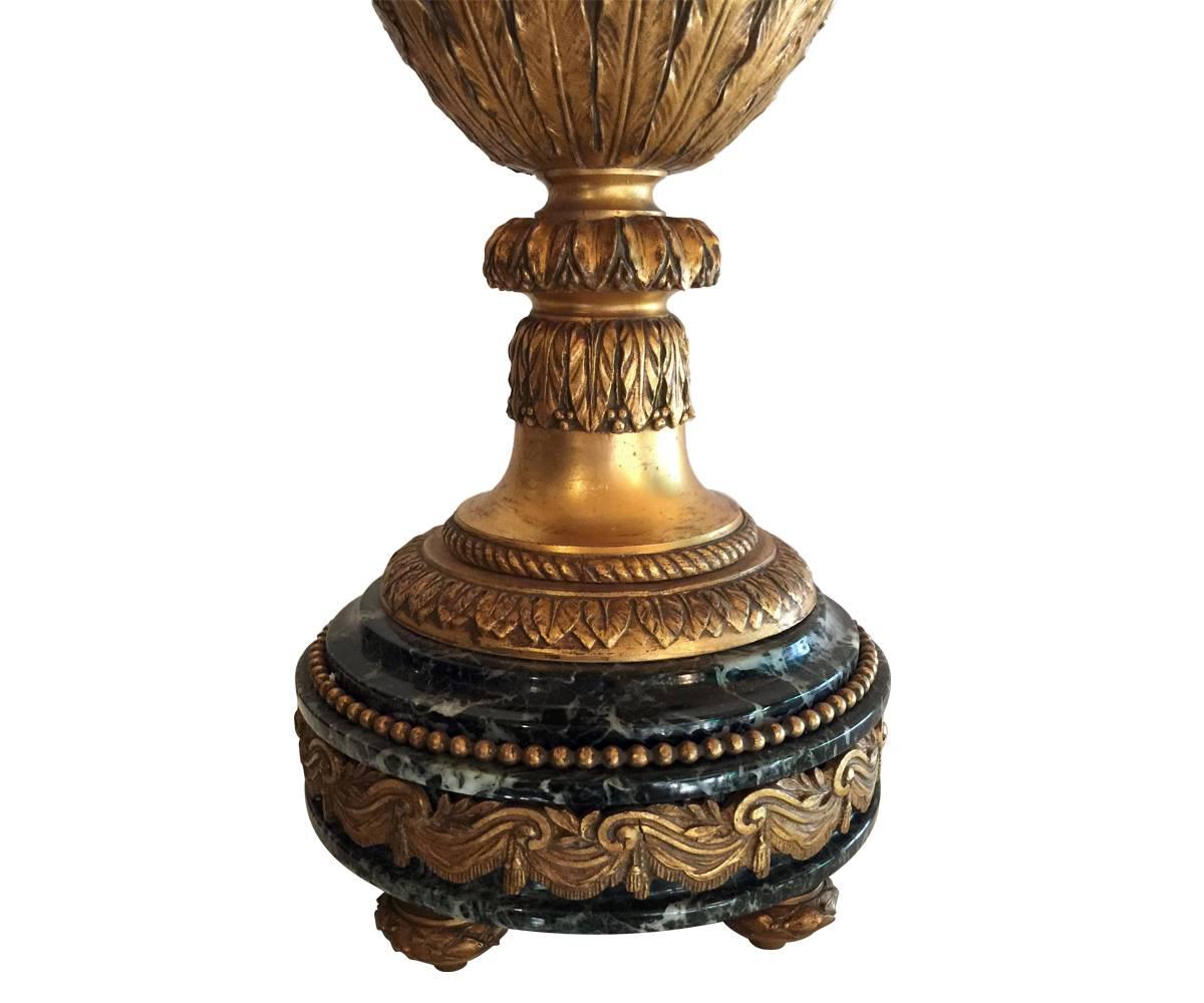 This is an antique gilt bronze ormolu urn that was nicely converted to a lamp. The ormolu includes a well crafted woman’s face among rose decorations.
