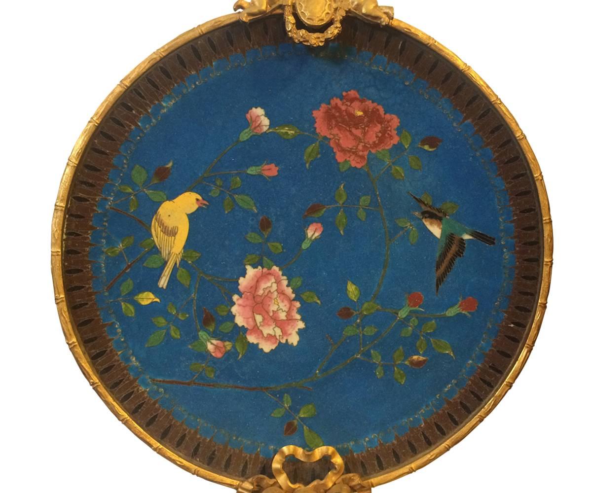 This is a great pair of antique French wall sconces with three arms for candles and two cherubs atop the piece all out of gilt bronze. The plates feature birds and flowers all with detailed and Fine cloisonné work.