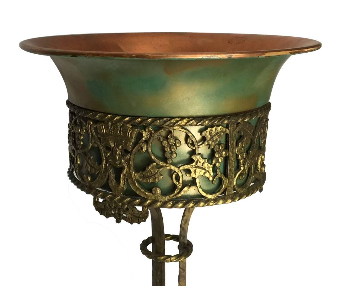 Offered is a good Oscar Bach bronze and iron planter that has a copper inset and is framed by a theatrical mask ring and is supported on an ornate post and base.