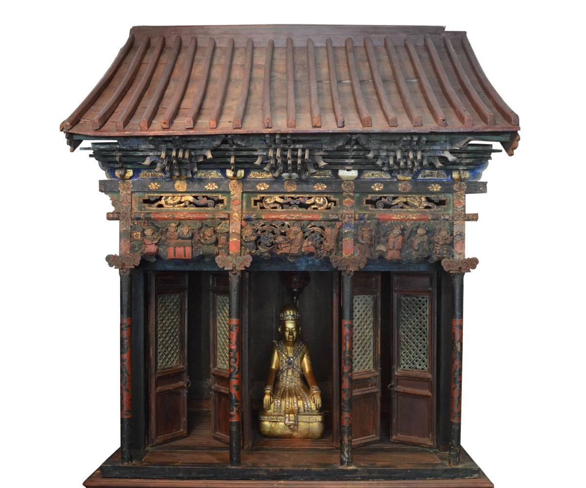 This piece is exquisite and quite unusual as it is a quite large antique, 18th century Chinese temple with hand-painted, gilt and carved wood features. The temple features six folding doors typical of those in China. The stand is not original to the