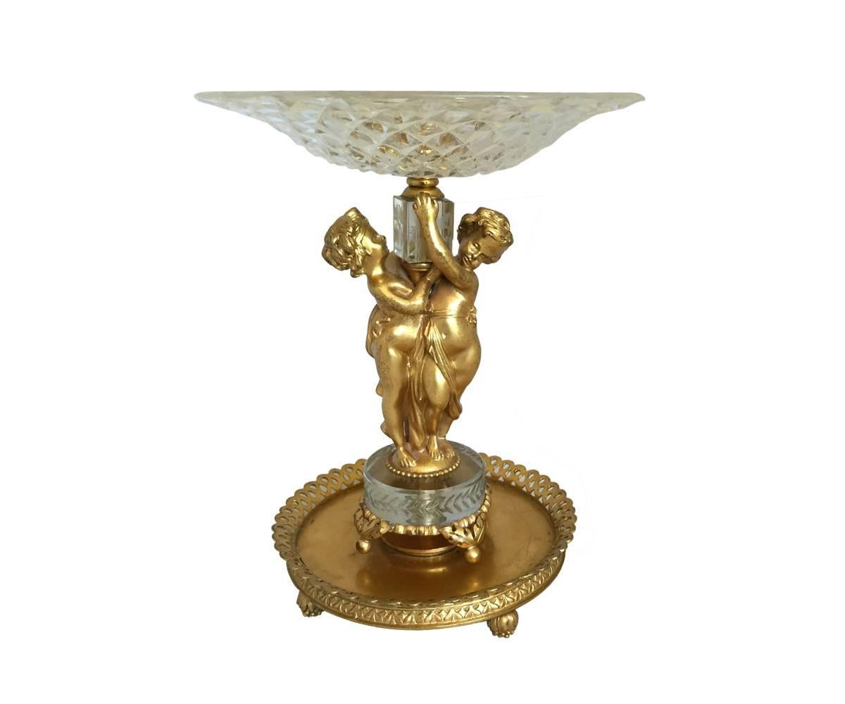 This gorgeous centerpiece is gold gilt bronze and has etched glass on the stem with two figurines holding each other and the bowl. The crystal is attributed to Baccarat.