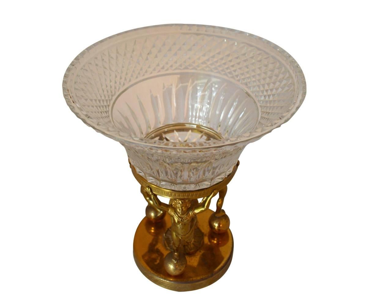 This centerpiece has three angels standing on a ball holding up a deep well cut crystal Baccarat bowl. 