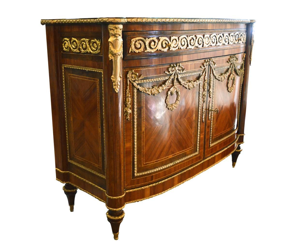 Magnificent French satinwood and bronze ormolu two doors Bombe
commode. Features satinwood veneer and inlaid wood, bronze garland swag and bronze ormolu add beautiful design all the way around this cabinet.