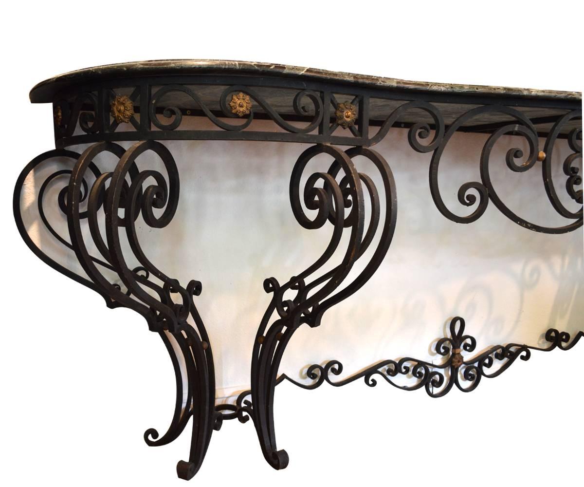 Large and decorative Louis XV style patinated with gilt accent wrought iron console table with marble top.