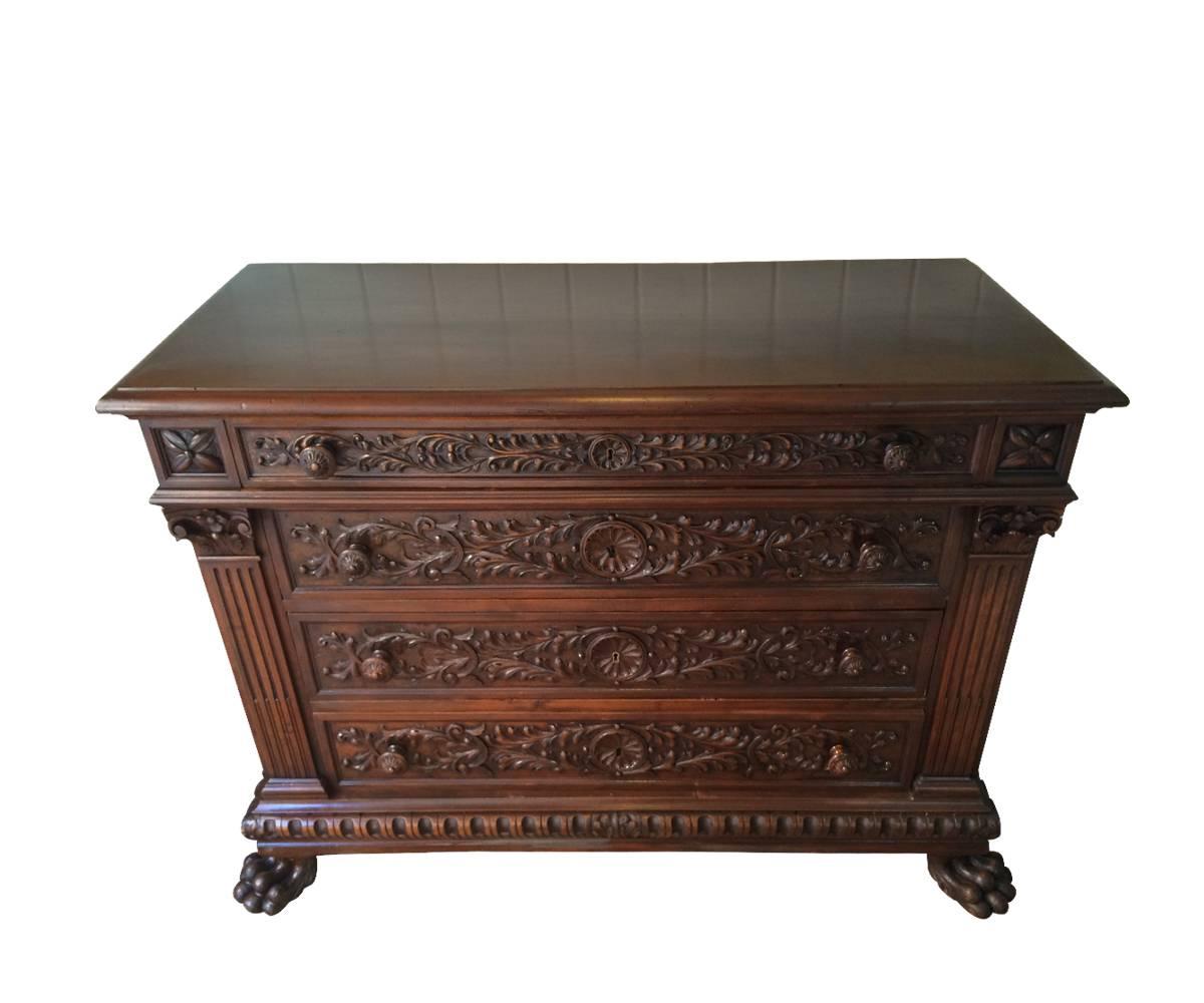 We proudly offer this 19th century Italian extremely well hand-carved walnut wood dresser with four drawers and carved fluted columns on sides resting upon lion feet. This piece has been professionally refinished to its original glory and would be