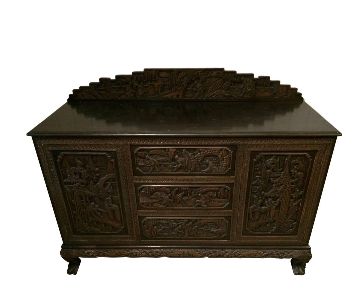 Proudly offered is a wonderful antique hand-carved Chinese sideboard with a back splash. We rarely see Chinese sideboards and this is a rare piece. It has two wonderfully carved doors on the side framing the center section having three useful