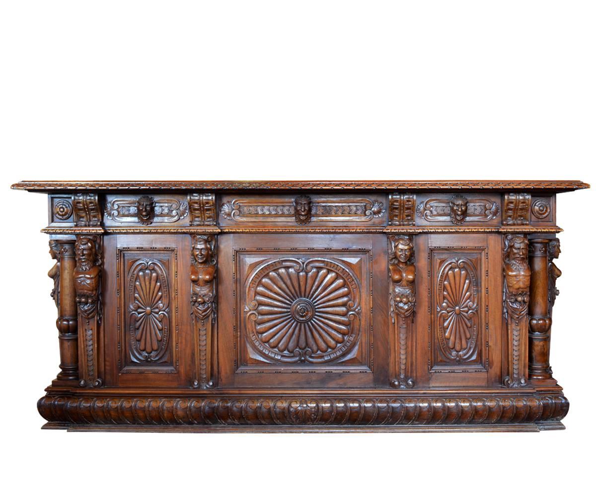 Exquisitely antique Italian hand-carved walnut wood desk that features columns and statuary on each corners with pull-out drawers. Matching book case features beautiful statuary and columns on corner post proving a framework for the wrought iron