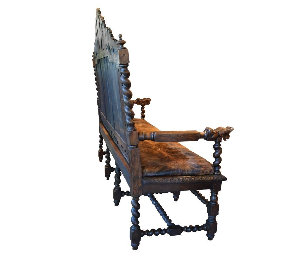 Offered is this fabulously carved bench with barley twists and a griffin top and arm rests. The cane back is surrounded by more carving. The seat is leather.