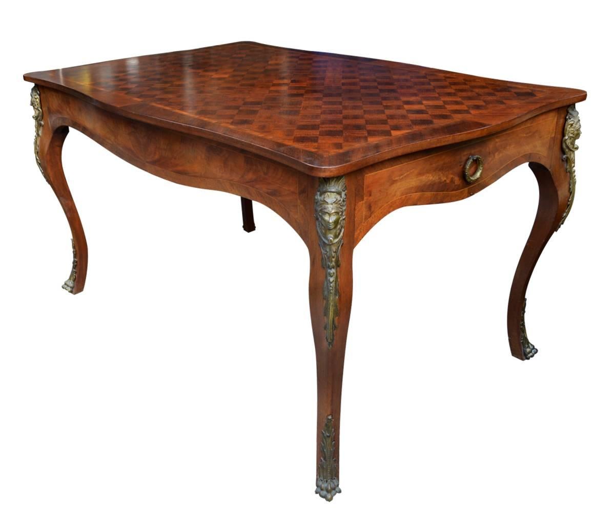 We proudly offer this French parquetry table with ormolu accents of a woman's face on the top of each leg and at more ormolu on each leg.