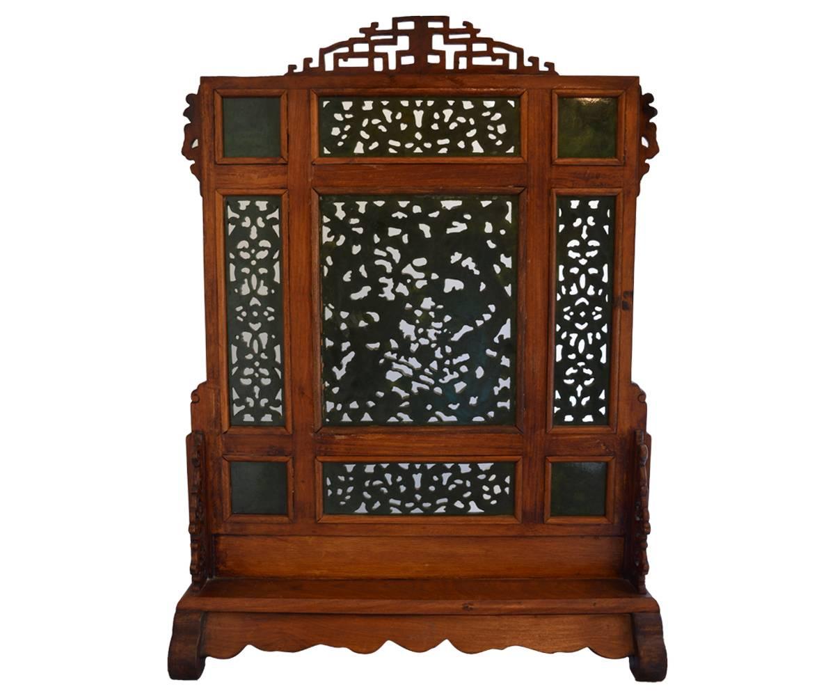 Offered is an excellent jade table screen with the ever popular dragon motif. There are actually nine separate jade panels. Five of the panels have open work carvings and the remaining four have Chinese script. The rosewood frame is accented with