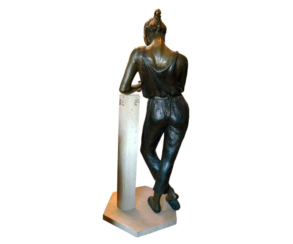 Offered is this signed lifesize bronze of a female in jumpsuit and sandals leaning of a pedestal and spinning her ring.