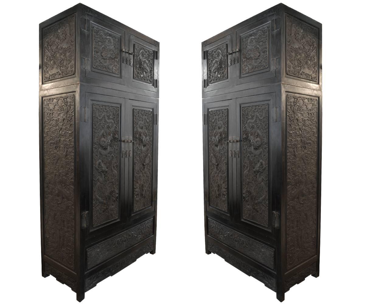 This is an absolutely exquisite pair of rare Chinese zitan cabinets with amazing hand carvings featuring dragons amongst clouds in the intricate details. Each cabinet is consists of two separate pieces, a larger bottom and smaller top section to