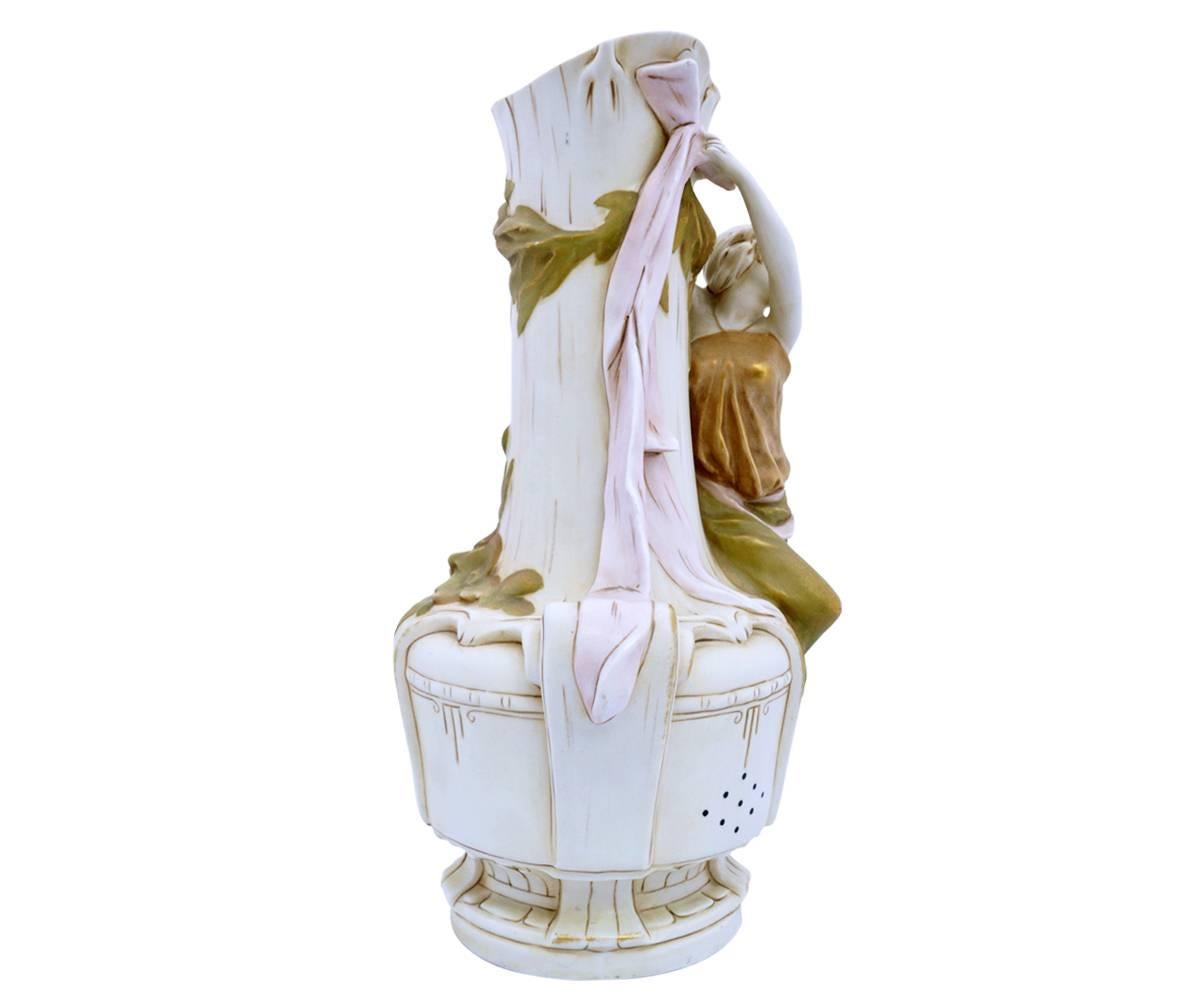 This is a gorgeous Royal Dux Art Nouveau vase with a hand-painted maiden clinging to the rim of an urn shaped vase.
