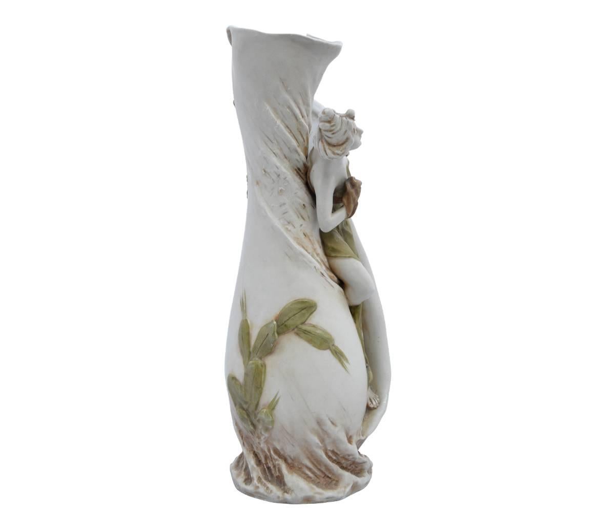 This fine Royal Dux vase in the Art Nouveau style features are beautiful woman with a robe draping from her shoulders. The lines of this piece are magnificent.