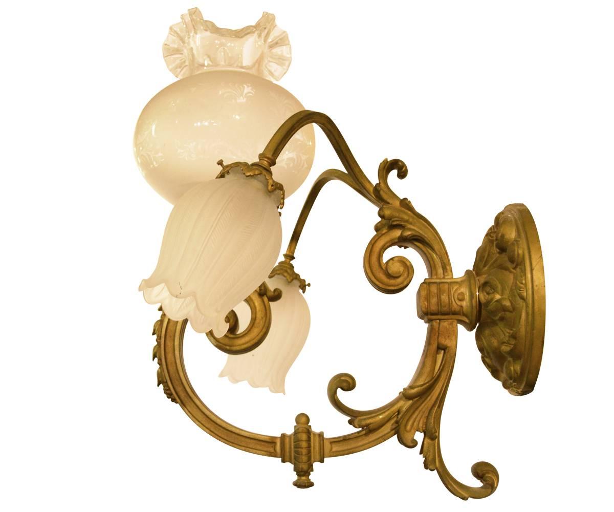 These French gilt bronze wall scones were originally gas and have been converted to electric. They are three-arm fixtures with two arms going down and one up.