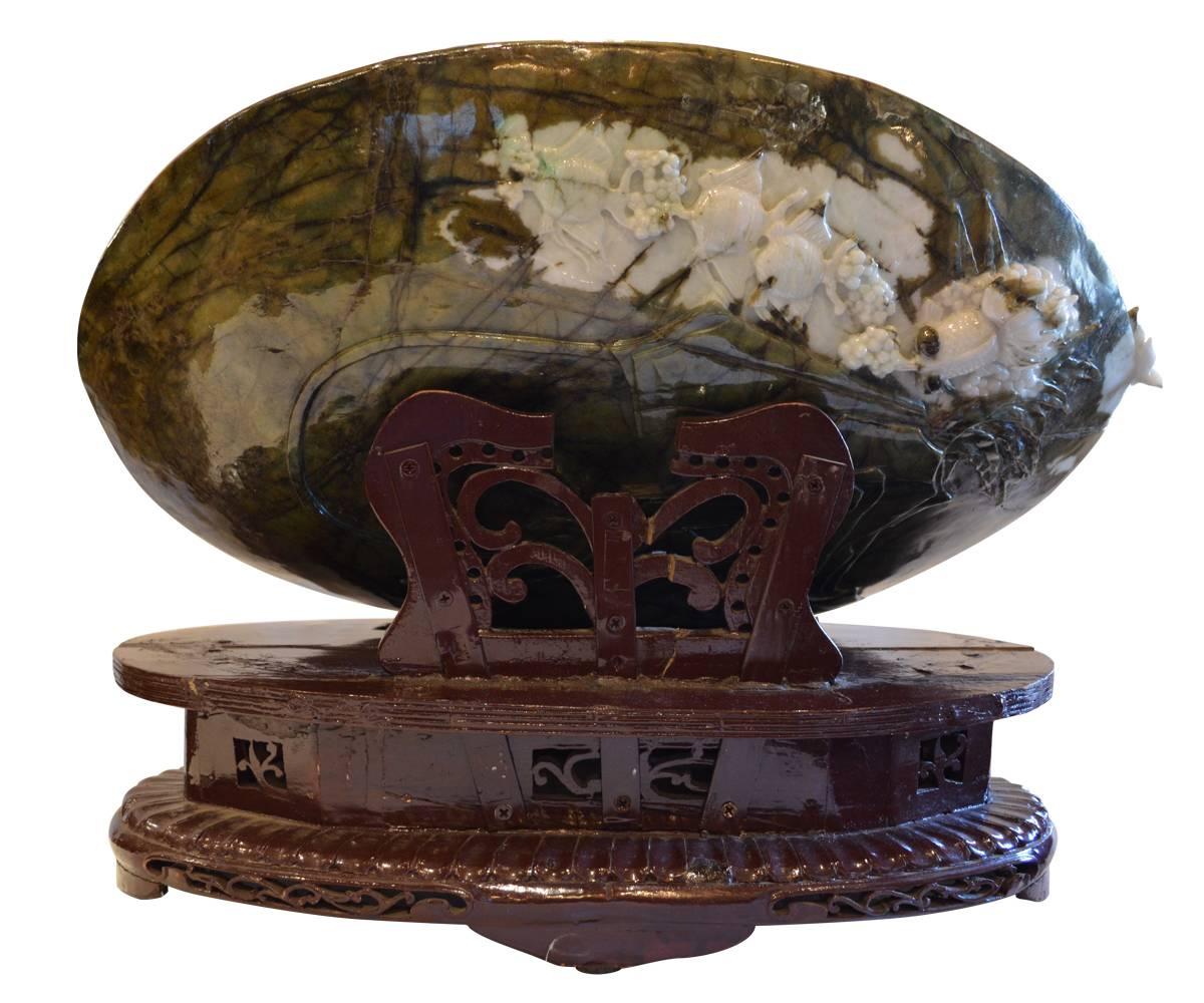This very large jade carving is a great example of how the master carver envisions the result prior to carving. Under the sea topic has a dark green background with the features projecting forth in wonderful site, make green and lavender. Included
