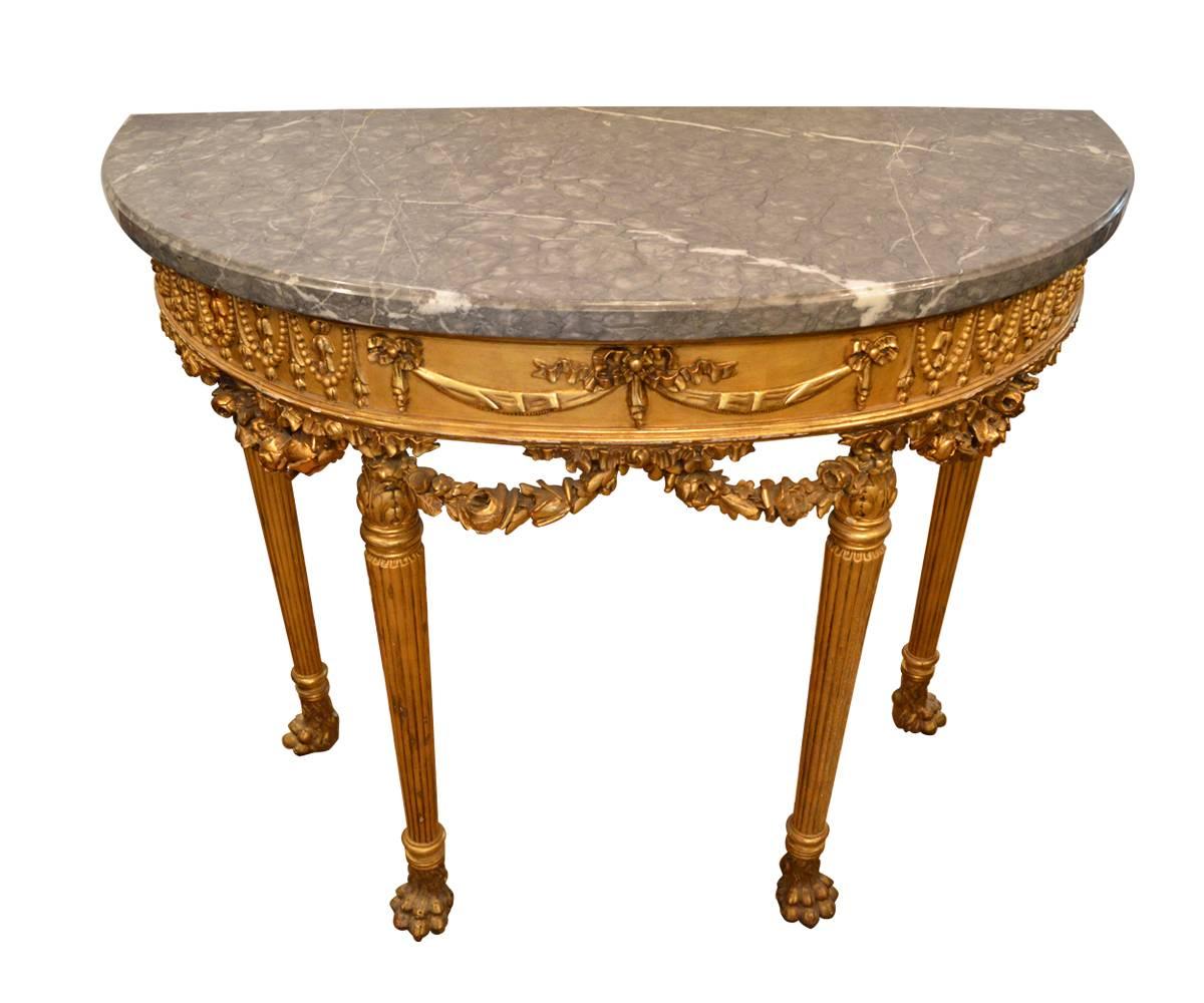 This console is in fabulous condition for its age as the gilt covering the intricate and well hand-carved wood is still bright and complete. This console features claw feet, straight spindle and grooved legs and apron featuring rose garland. The