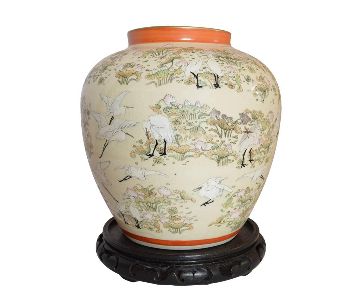 Offered is the large pair of antique Japanese Satsuma earthwork jar, each of bulls form with gilt rim, orange accents and a continuous scene of enameled cranes amid flora, reserved an a crackle glaze. There is a gilt mark on the base. The jars each