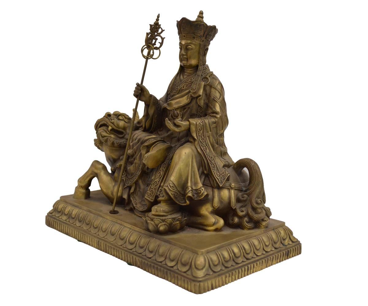 This Buddha or Quan Yin is a Chinese statue made of bronze. The figure is seated upon a conquered beast with one foot resting on a lotus flower.