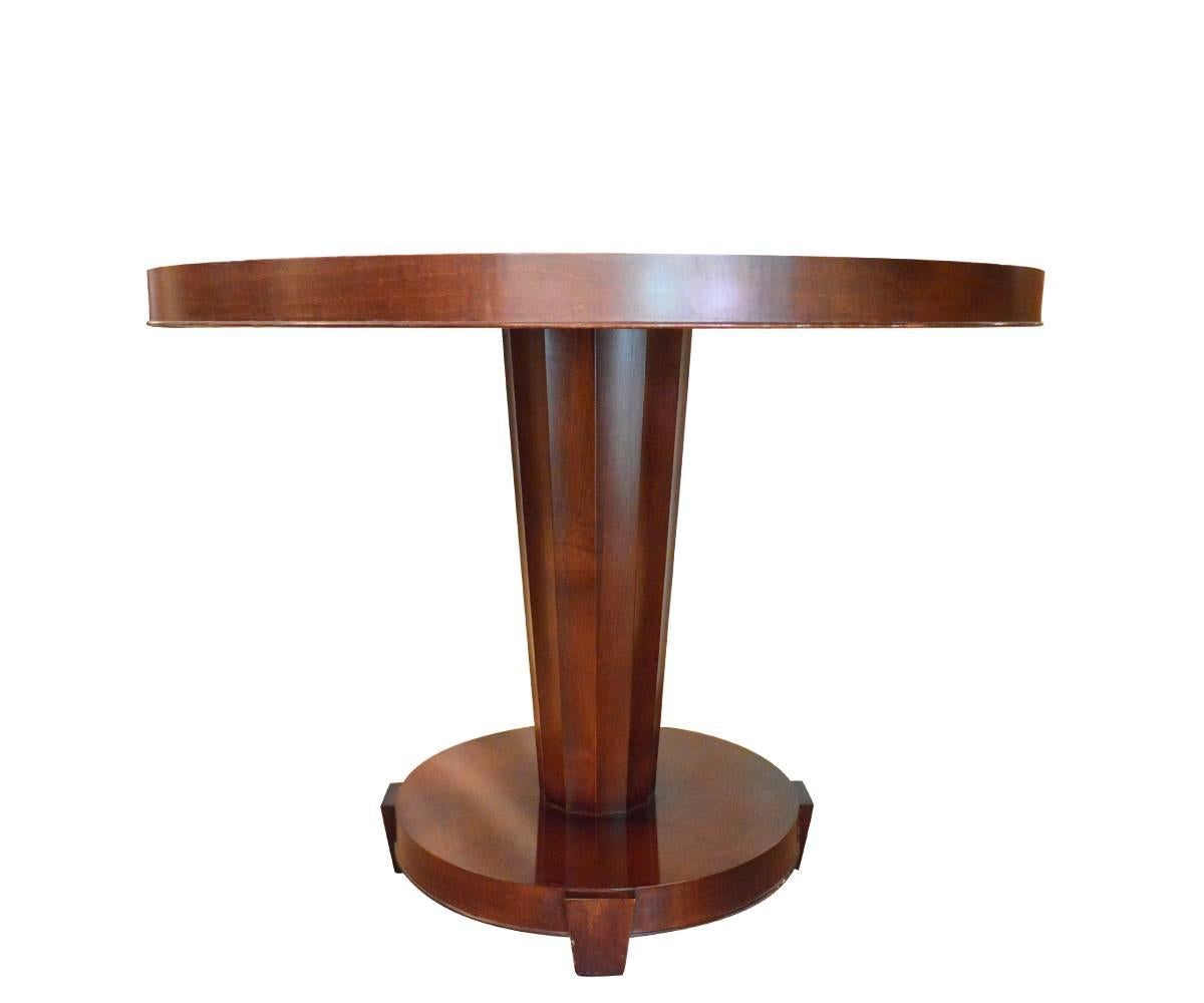 Magnificent Mid-Century Modern mahogany round table with a column like fluted stem bearing on a round base with three legs and a sunburst pattern on the top. This is a great table for foyer or dinette placing.