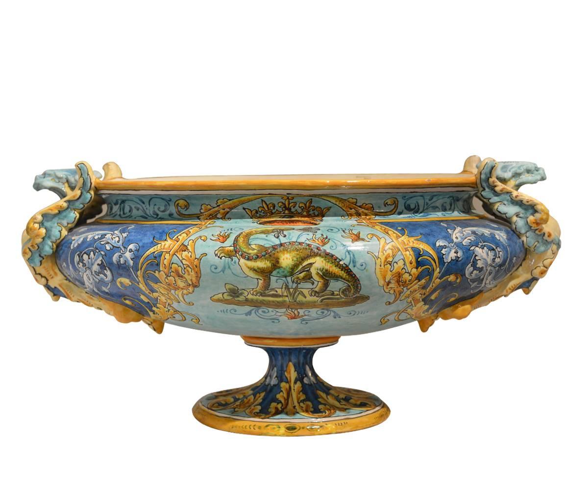 Antique French painted ceramic centerpiece featuring a creature on one side, wings on the other, both topped by a crown. There are two griffins used as handles. It has beautiful craftsmanship and is a great addition to any room.