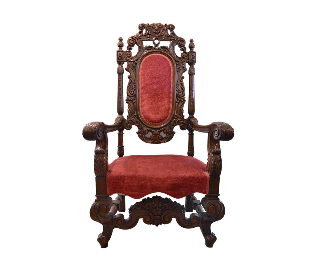 These massive chairs are hand-carved walnut with acanthus accents. They are extremely comfortable. The carvings continue on to the stretcher. The fabric appears to be original and thus the seat likely needs to be reworked which could be done at an