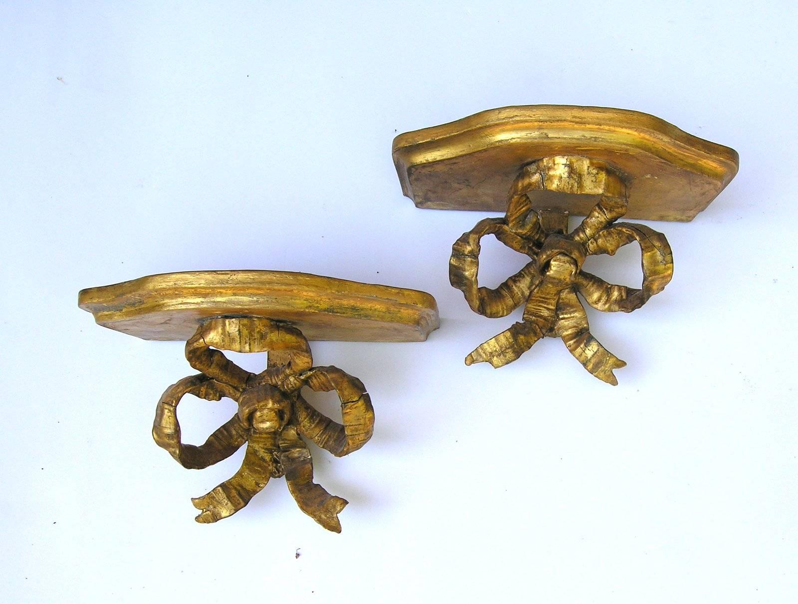 A pair of English 18th century gold leaf carved wood bow sconces, with shelf.