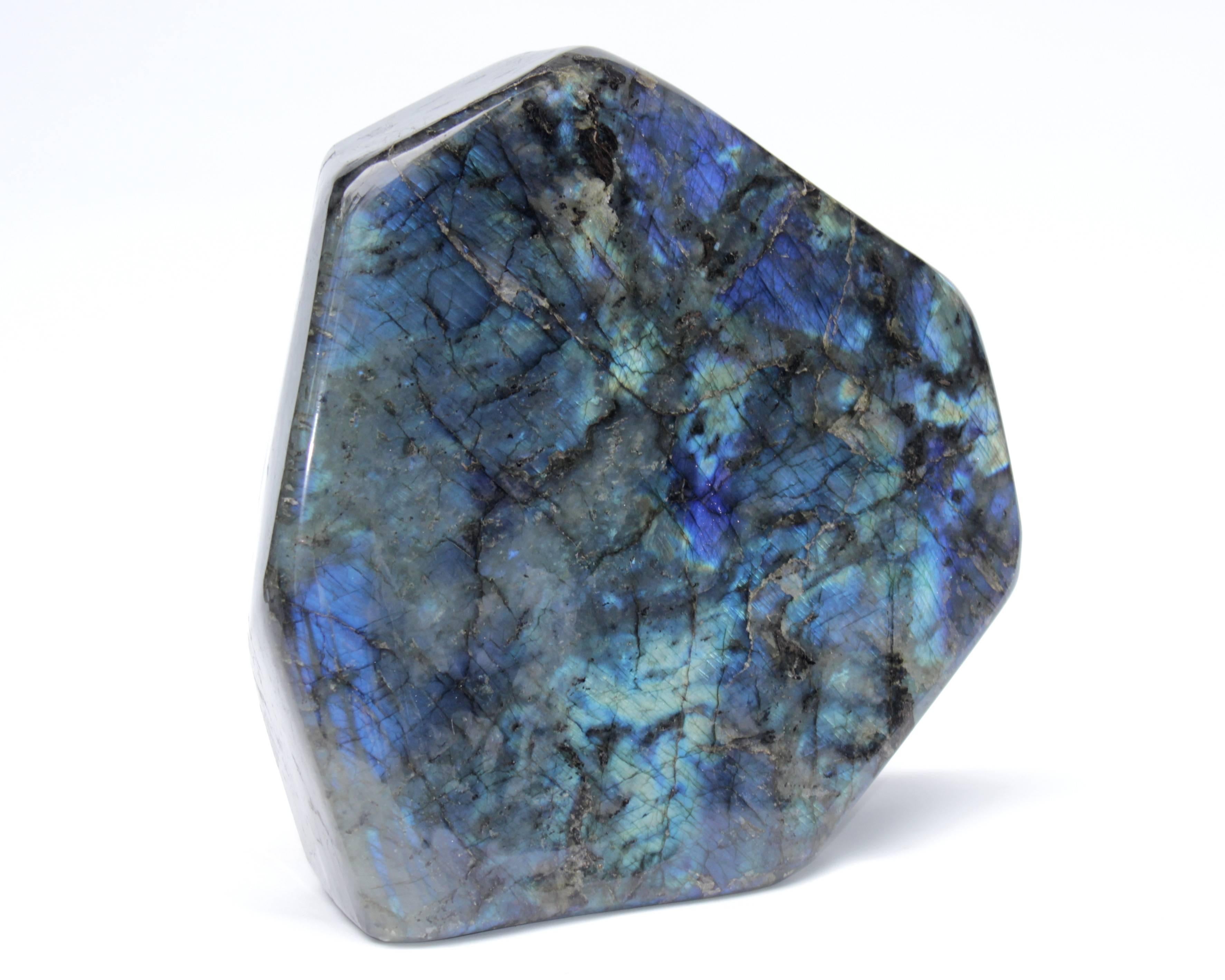 This is a large natural specimen piece of polished organic Labradorite. Polished on all sides. Labradorite is a plagioclase feldspar with an iridescent play-of-color that is often used as a gemstone. It is so well known for these spectacular