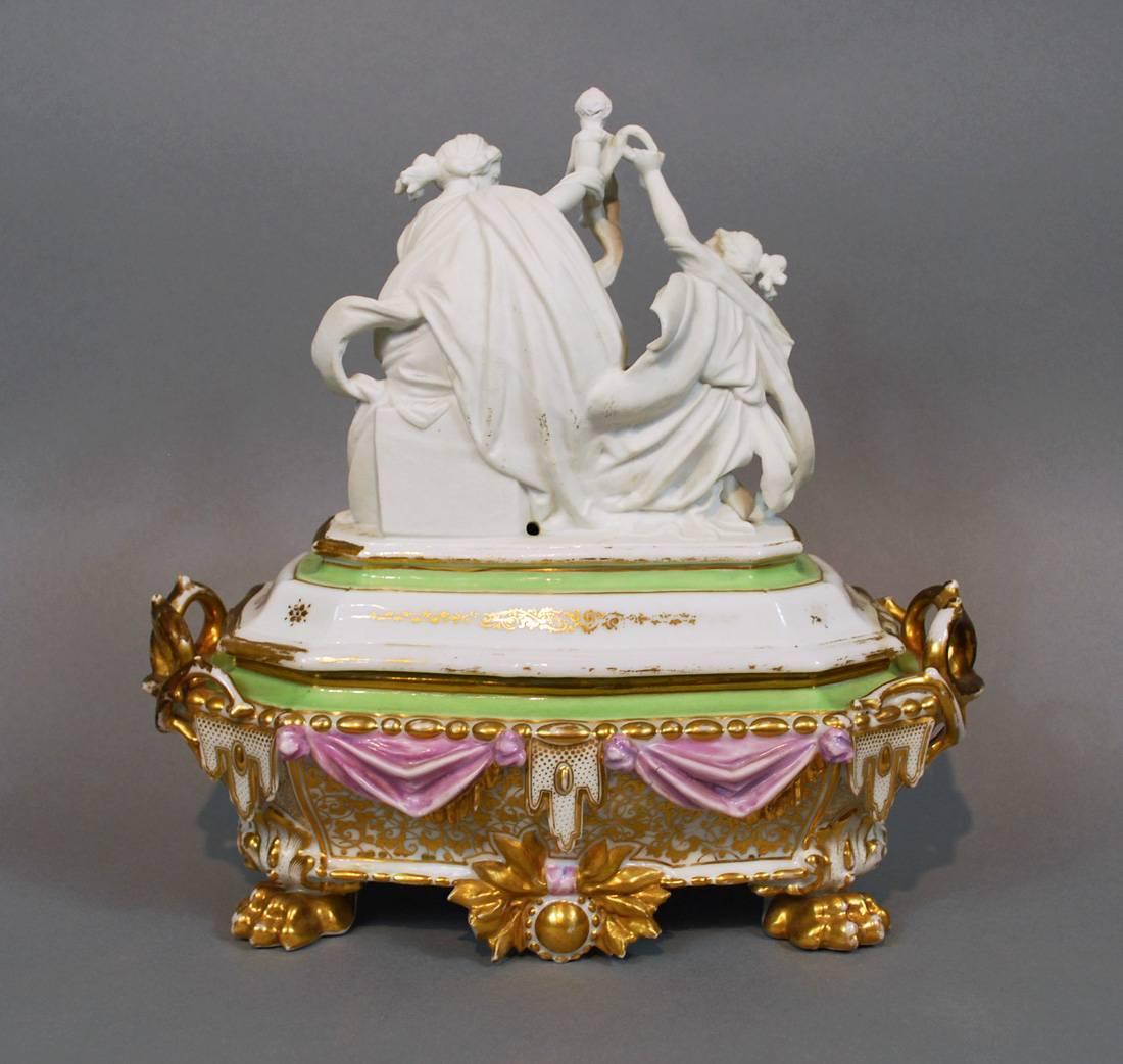 Étonnante boîte en porcelaine de l'Ancien Paris avec un groupe de sculptures pariennes figuratives sur le dessus. 

La boîte présente un mélange de détails dorés peints à la main et transférés, accentués par un glaçage lavande et écume de mer. La