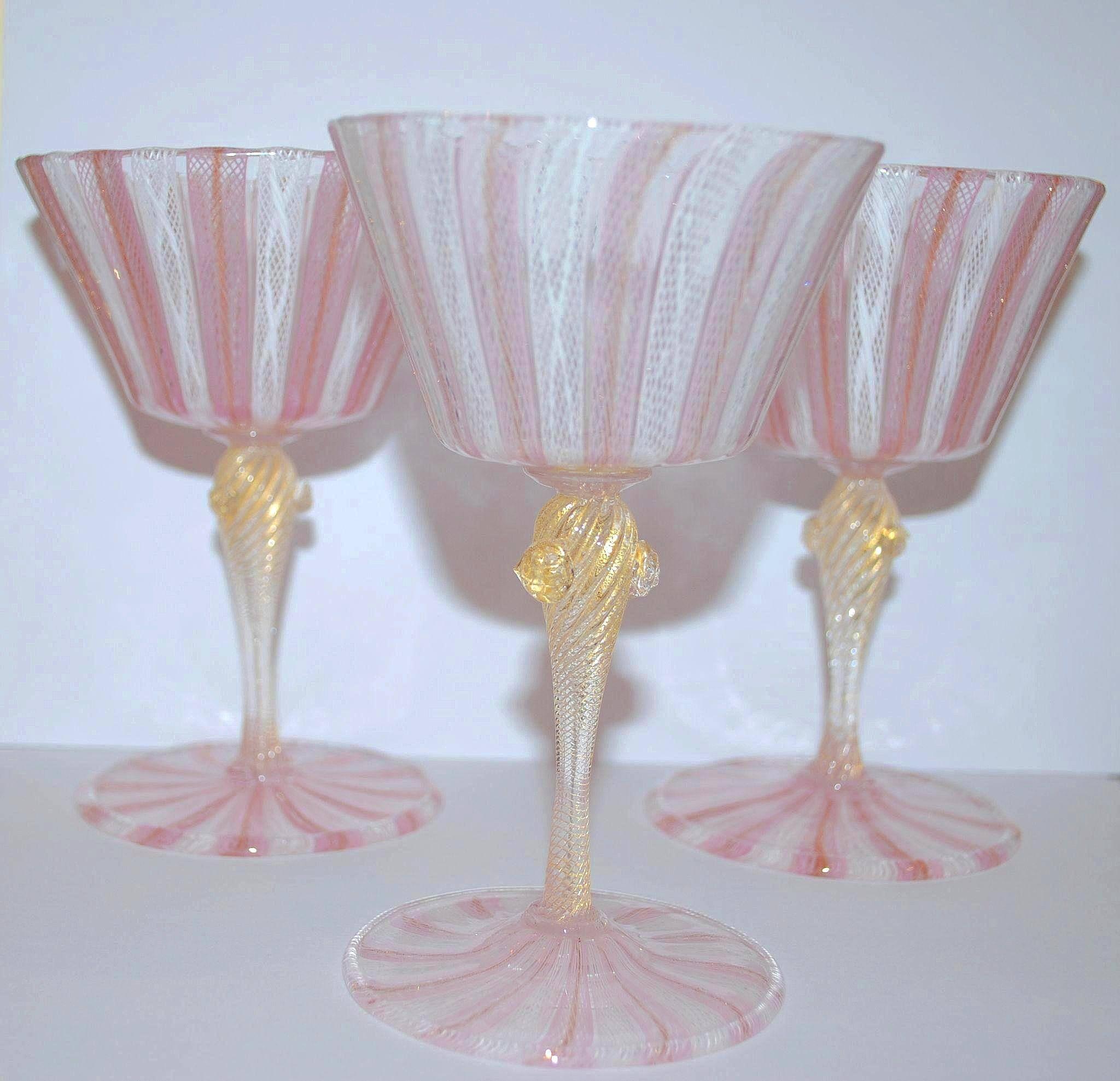An exquisite set of ten vintage hand blown glass Venetian Murano glasses.

This set features pink, white and clear glass in the latticino design, all radiating out from the central point. Gold flakes are suspended throughout the stem and parts of