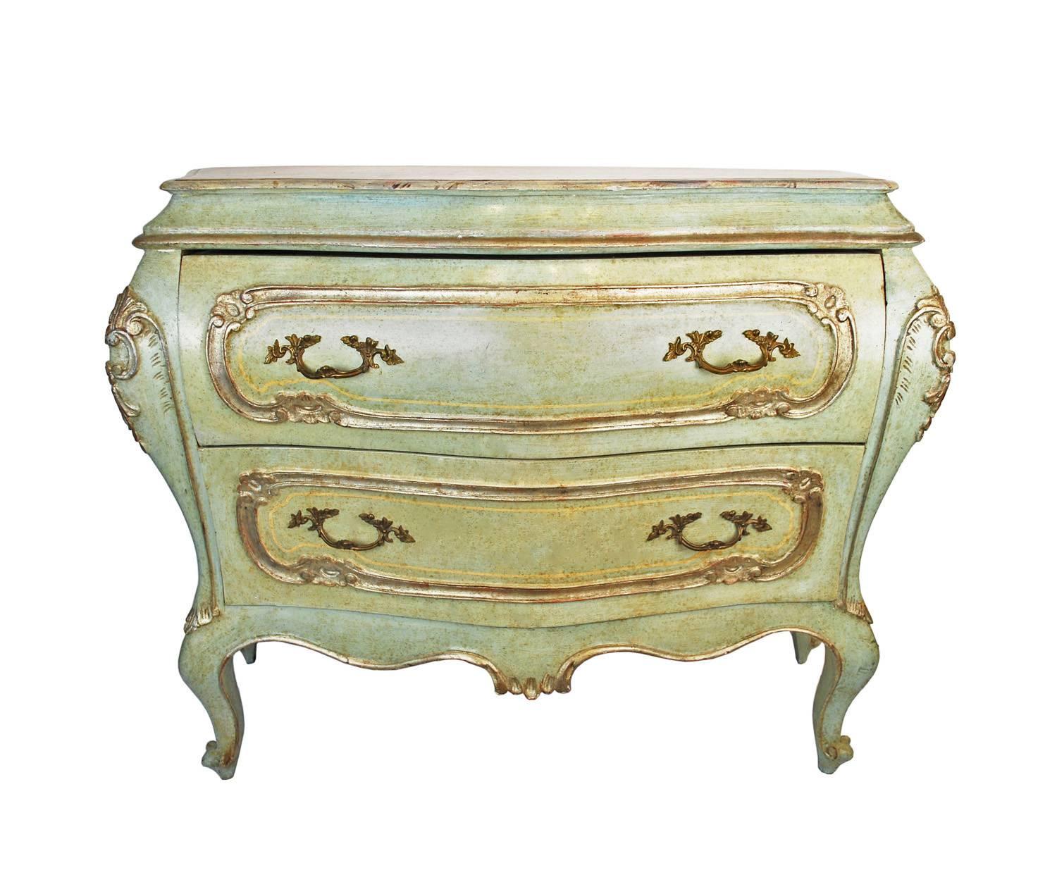 A nice light green pair of vintage Venetian bombe chests with distressed paint and painted faux marble-top. Distressed beautiful celadon paint accented by thin cream stripe detailing and silver toned embellished relief carving throughout. The tops