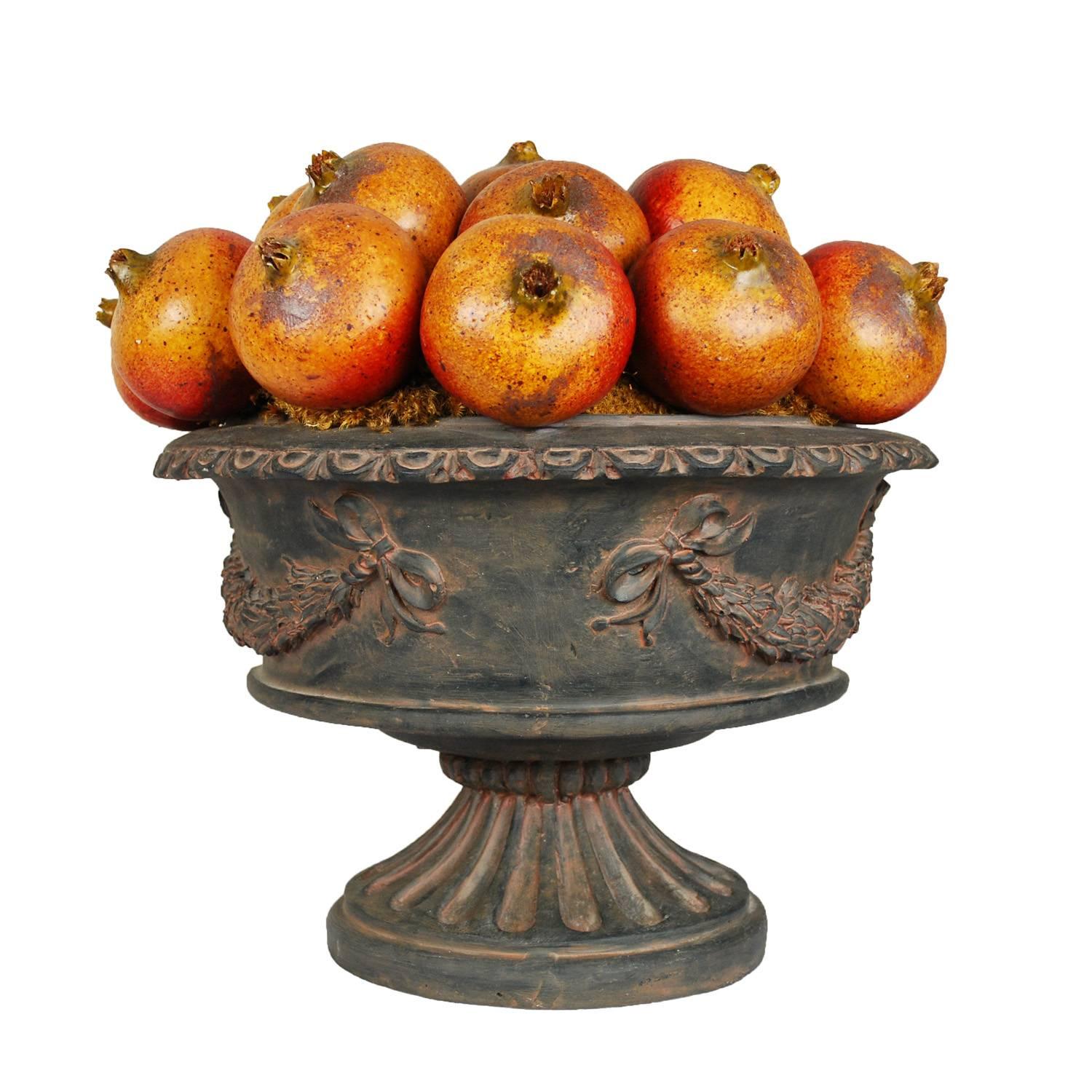 Un bellissimo vaso centrotavola decorativo con melograni artificiali. L'urna con finitura affilata è di colore marrone tenue con tonalità calde per dare l'impressione dell'età. Copiosi melograni artificiali realistici sono appollaiati sulla sommità