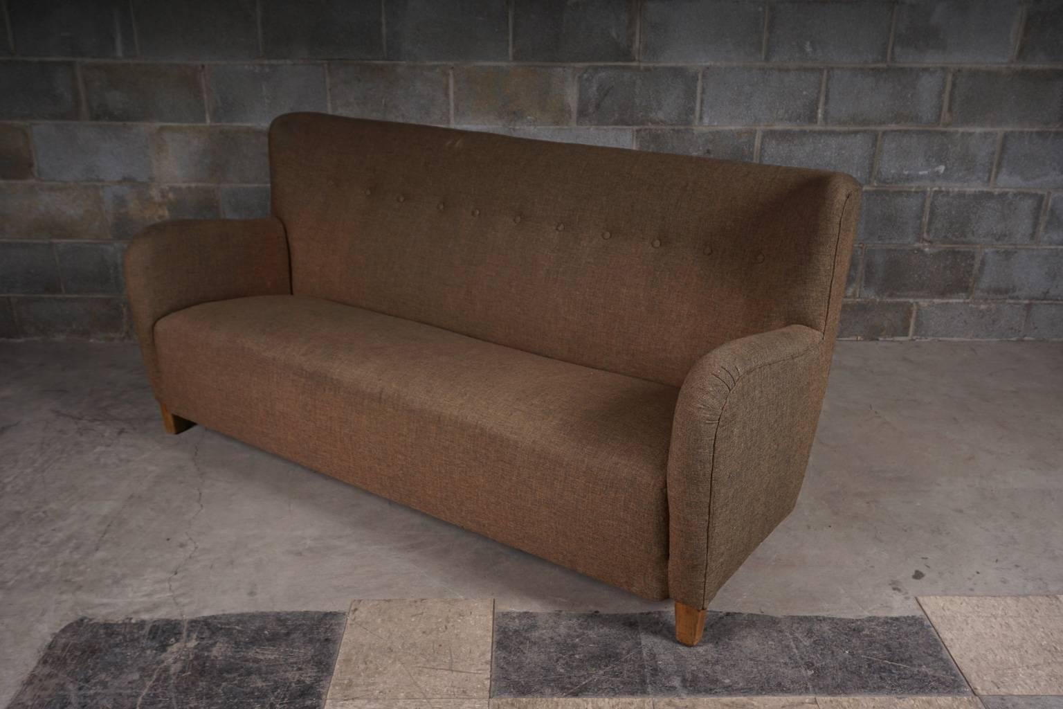 Three-seat Mid-Century Danish sofa upholstered in original brown fabric. Button fitted on the back. Very good quality and design.