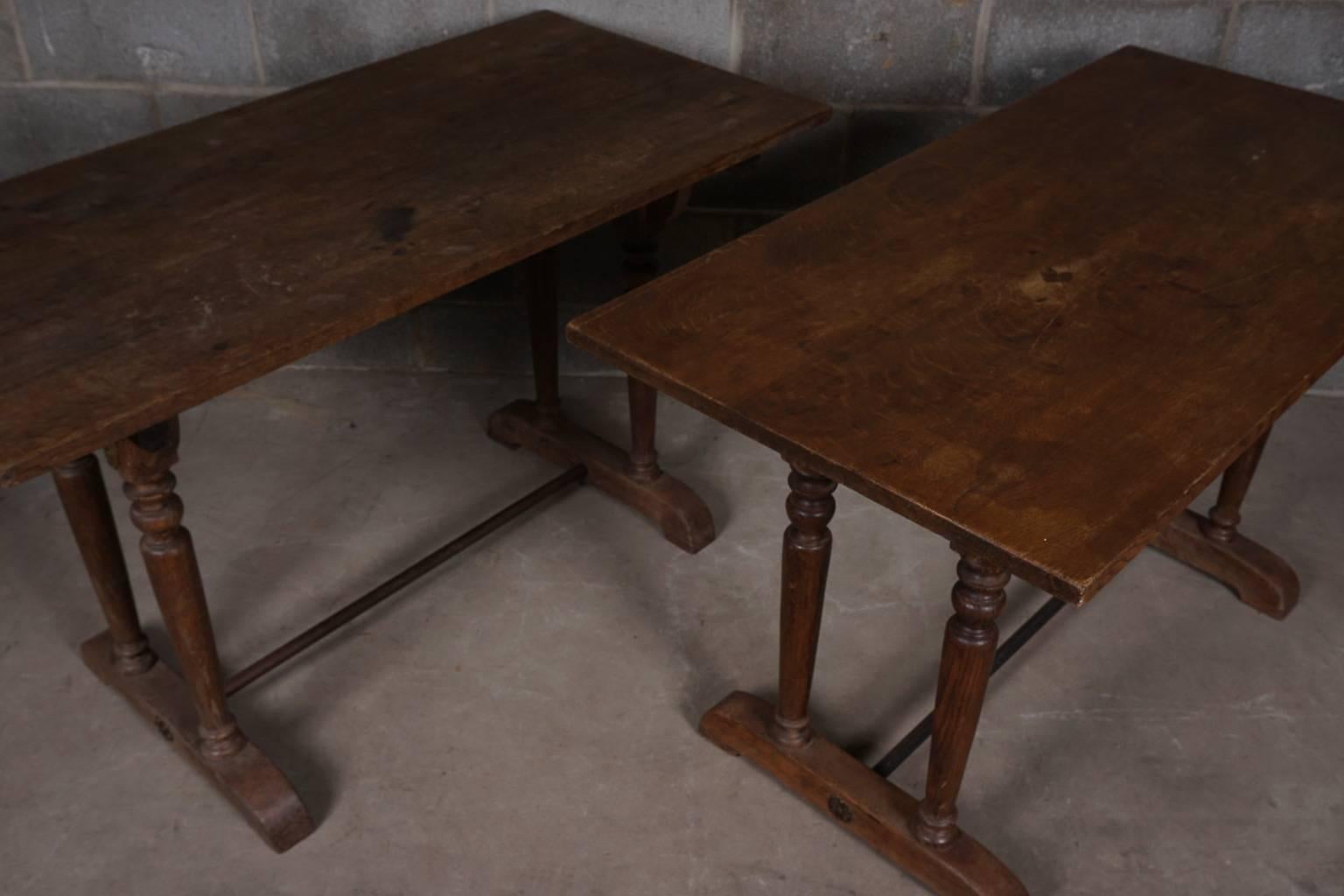 Pair of French bistro tables in oak. Original metal support connects base at the bottom. Nice, lightly used patina.