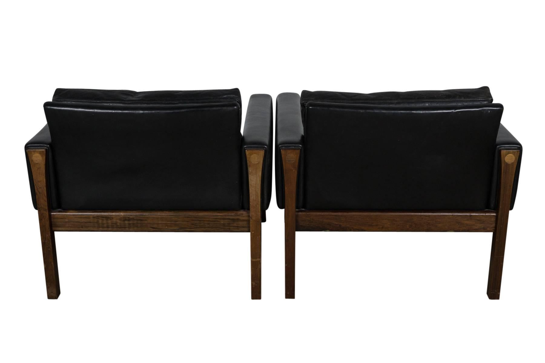 Rare pair of elegant rosewood and black leather chairs designed by Hans Wegner. Original, supple leather. Designed in 1962 for AP Stolen, Denmark.