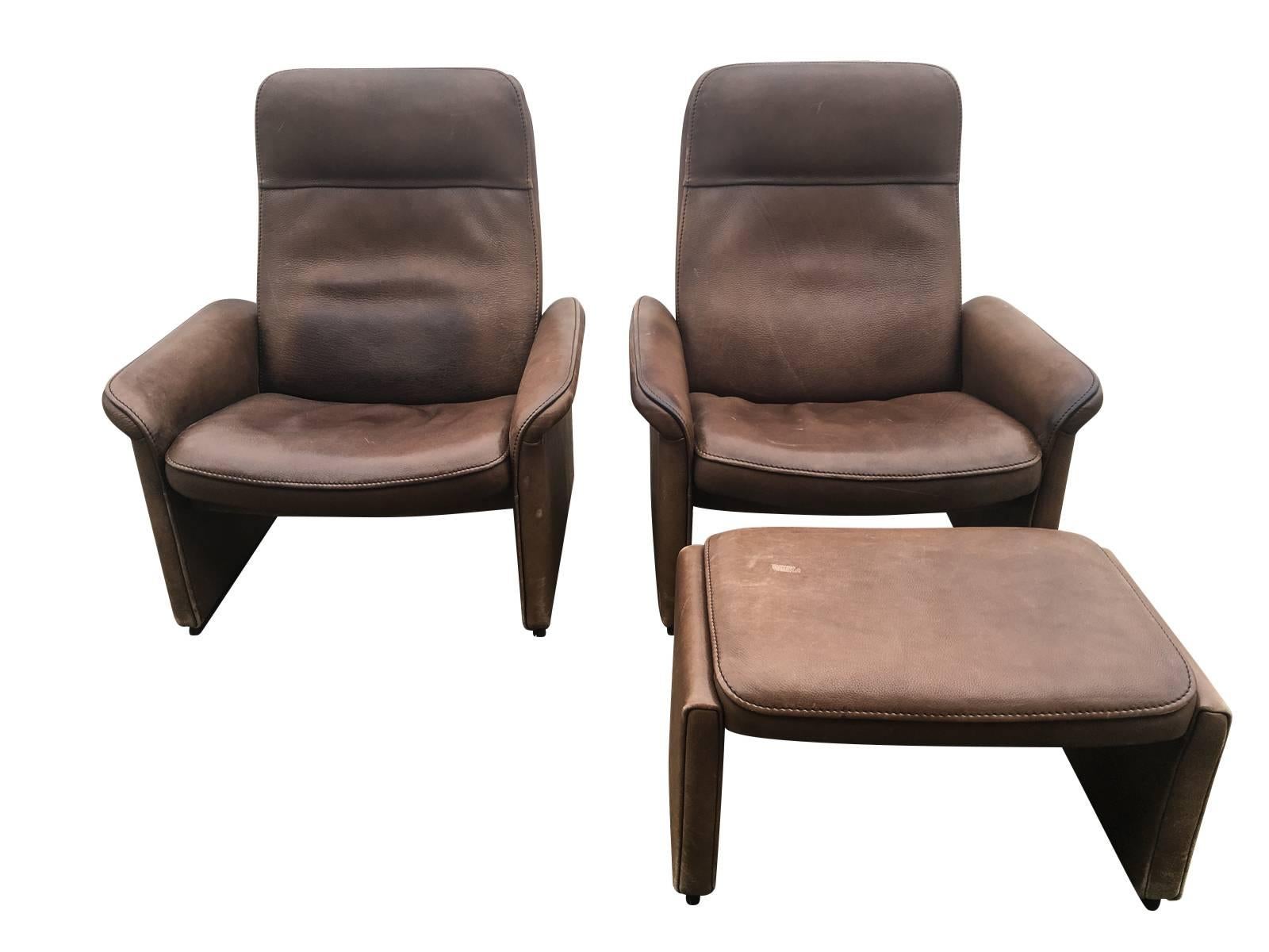 Pair of reclining leather lounge chairs manufactured by De Sede, Switzerland in thick buffalo leather. One ottoman included.