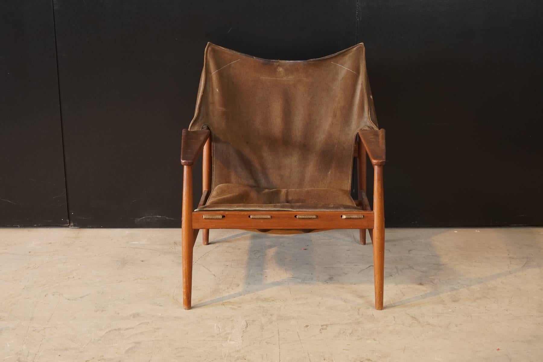1960s Safari chair by Hans Olsen for Viskadalens Mobelfabrik AB, Sweden. Suede sling with three-buckle support fitted over a solid teak frame with carved armrests.