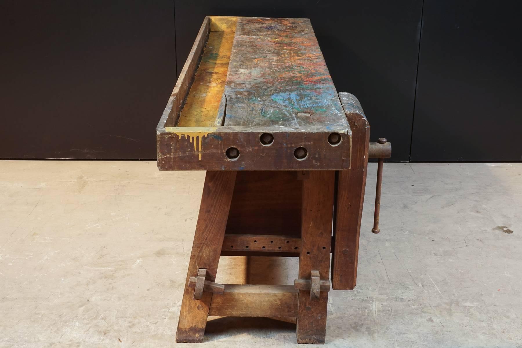 Primitive work bench from France, circa 1930. Very nice surface with original paint. Functioning clamp.