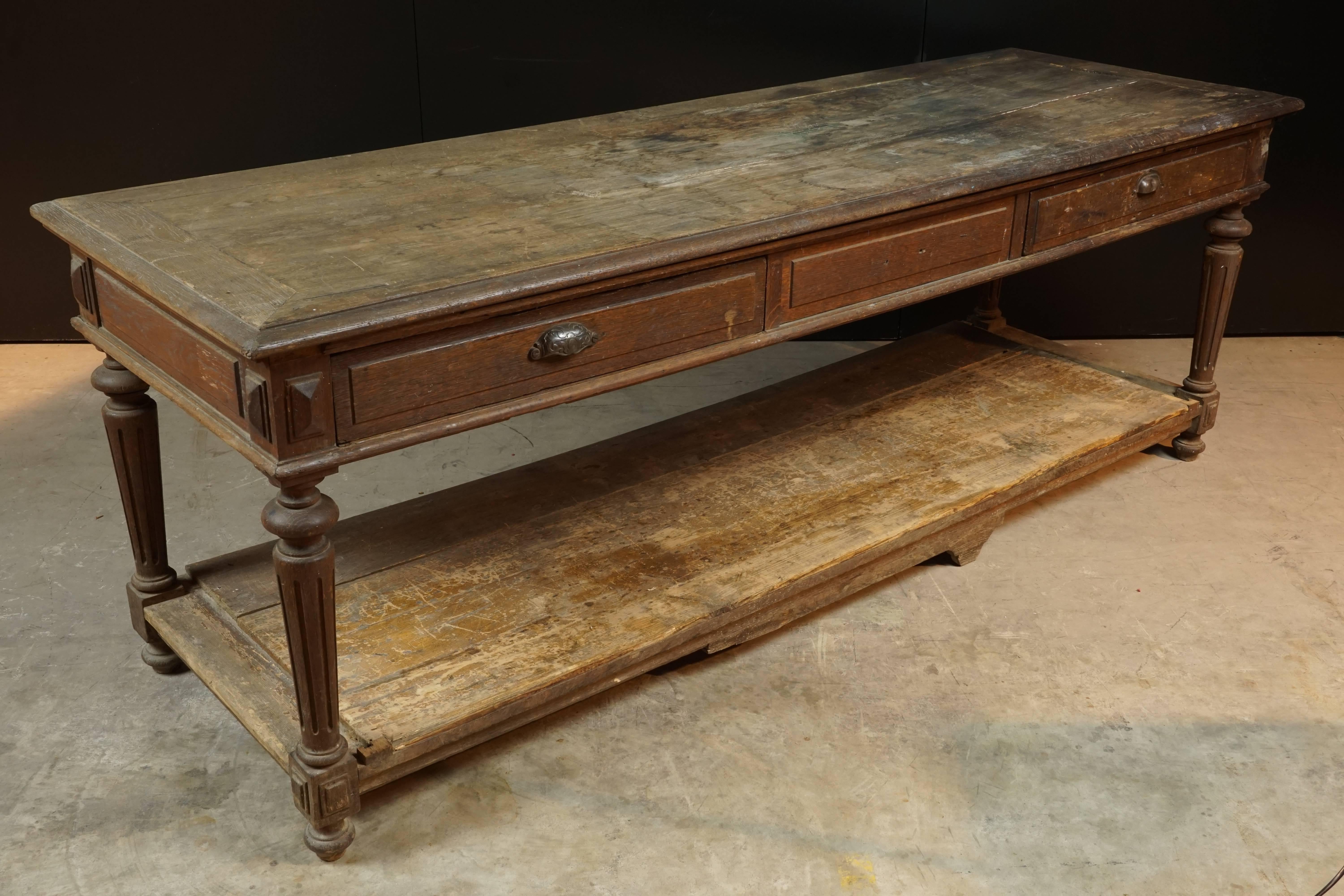 Early French draper table, circa 1880. Solid oak construction with superb patina and wear. Two drawers with original hardware.