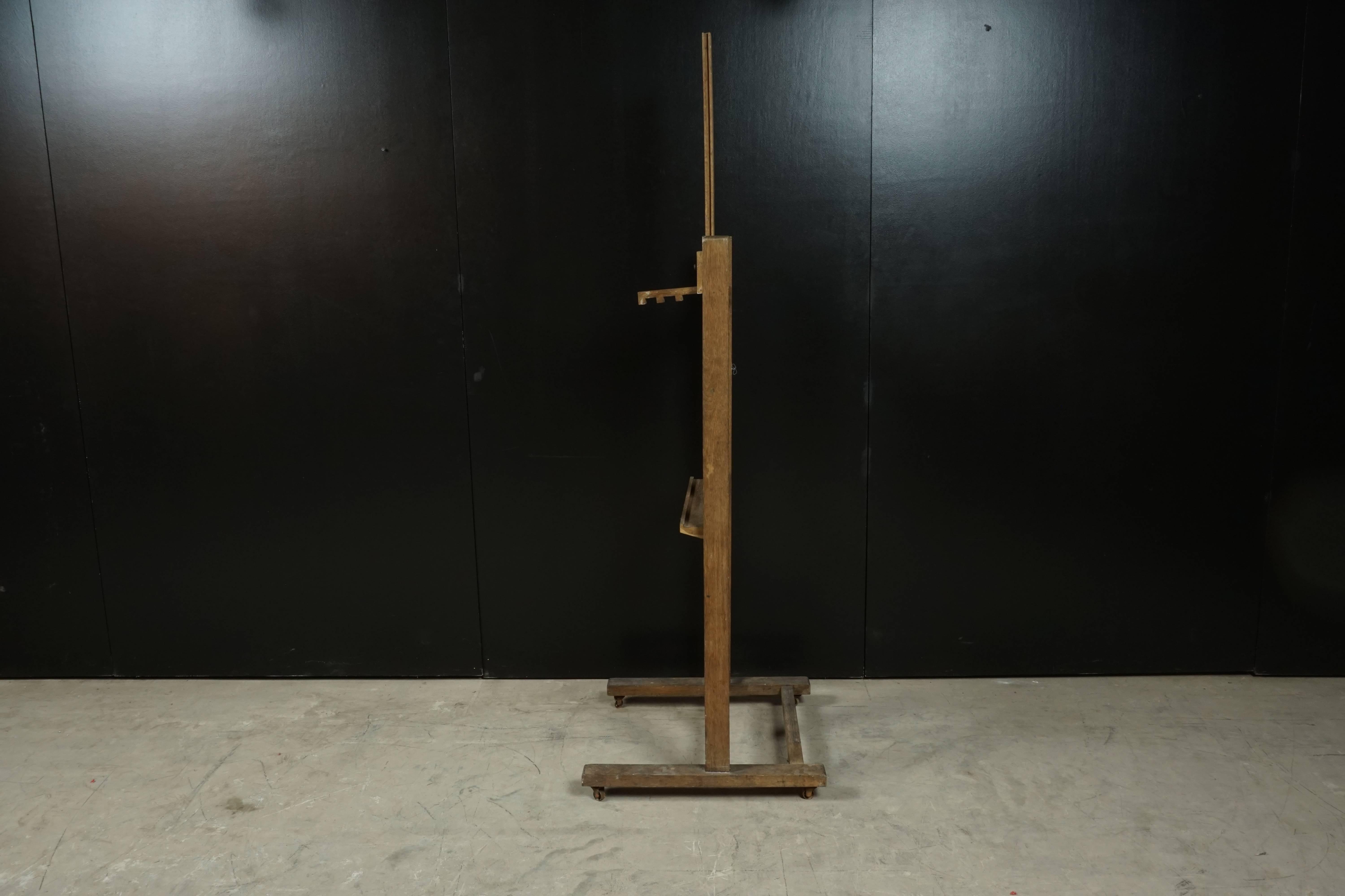 French Artist's Easel in oak, circa 1950. Adjustable shelf with original brass hardware. Height adjustable - in image height is 88