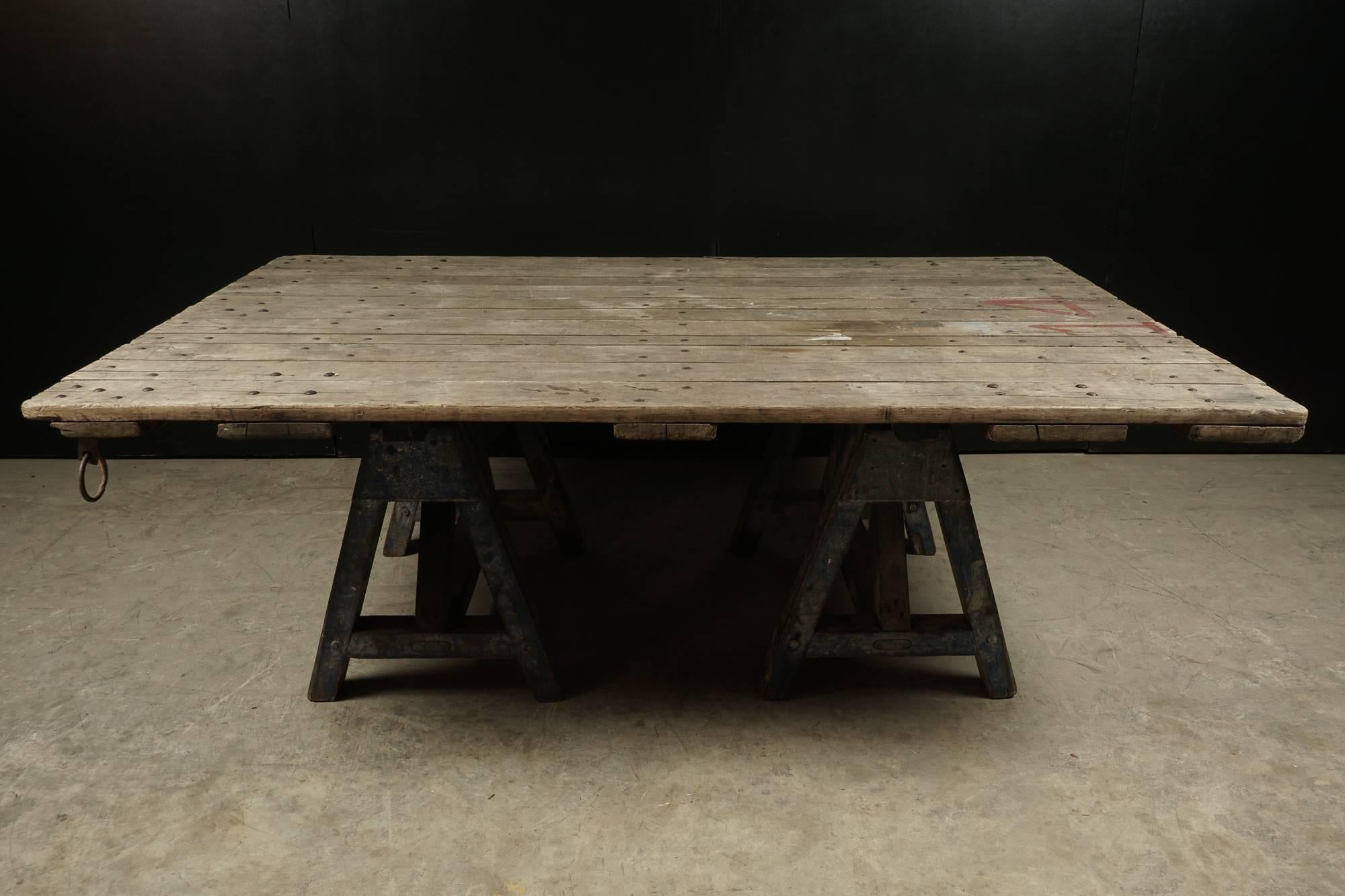 Large dining table with sawhorse base, circa 1920. Top originally from an oyster skiff in Massachusetts. Bases originally from, France. Superb patina and wear.