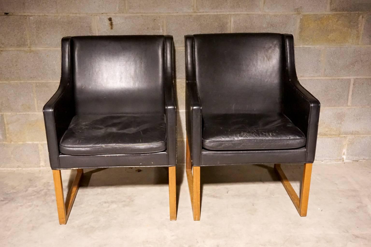 Pair of leather chairs designed by Borge Mogensen, model 3246. Black leather with oak legs. Age related wear and use.