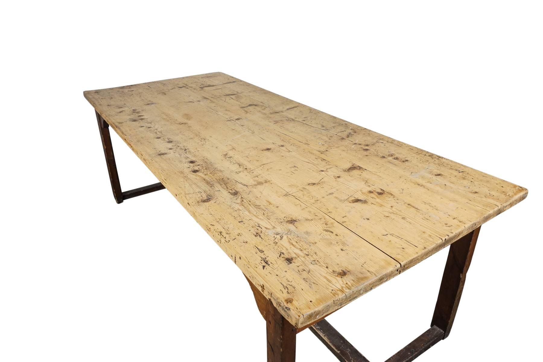 Pine farm table from France with nice wear and patina. Stretcher base.