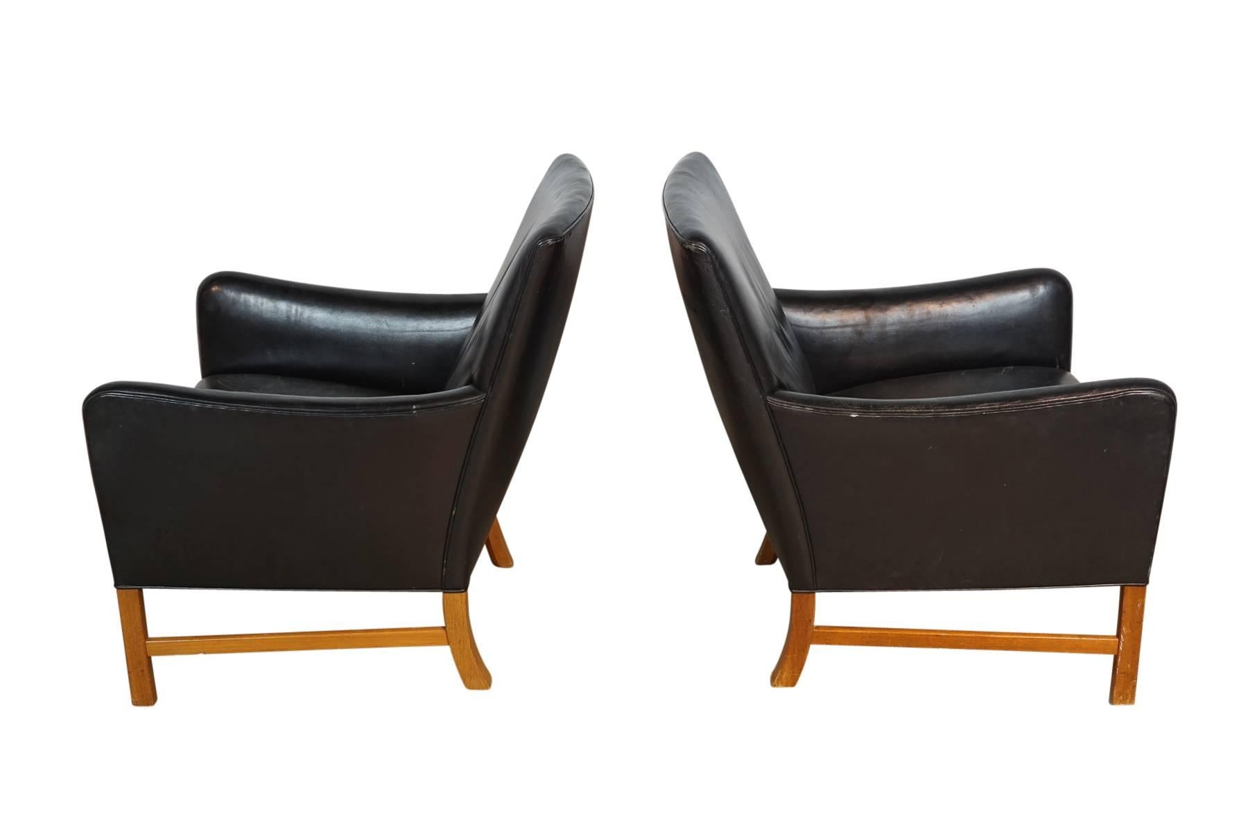 Superb pair of Ole Wanscher lounge chairs in original black leather on a solid mahogany frame. Produced by A.J. Iversen, Denmark.