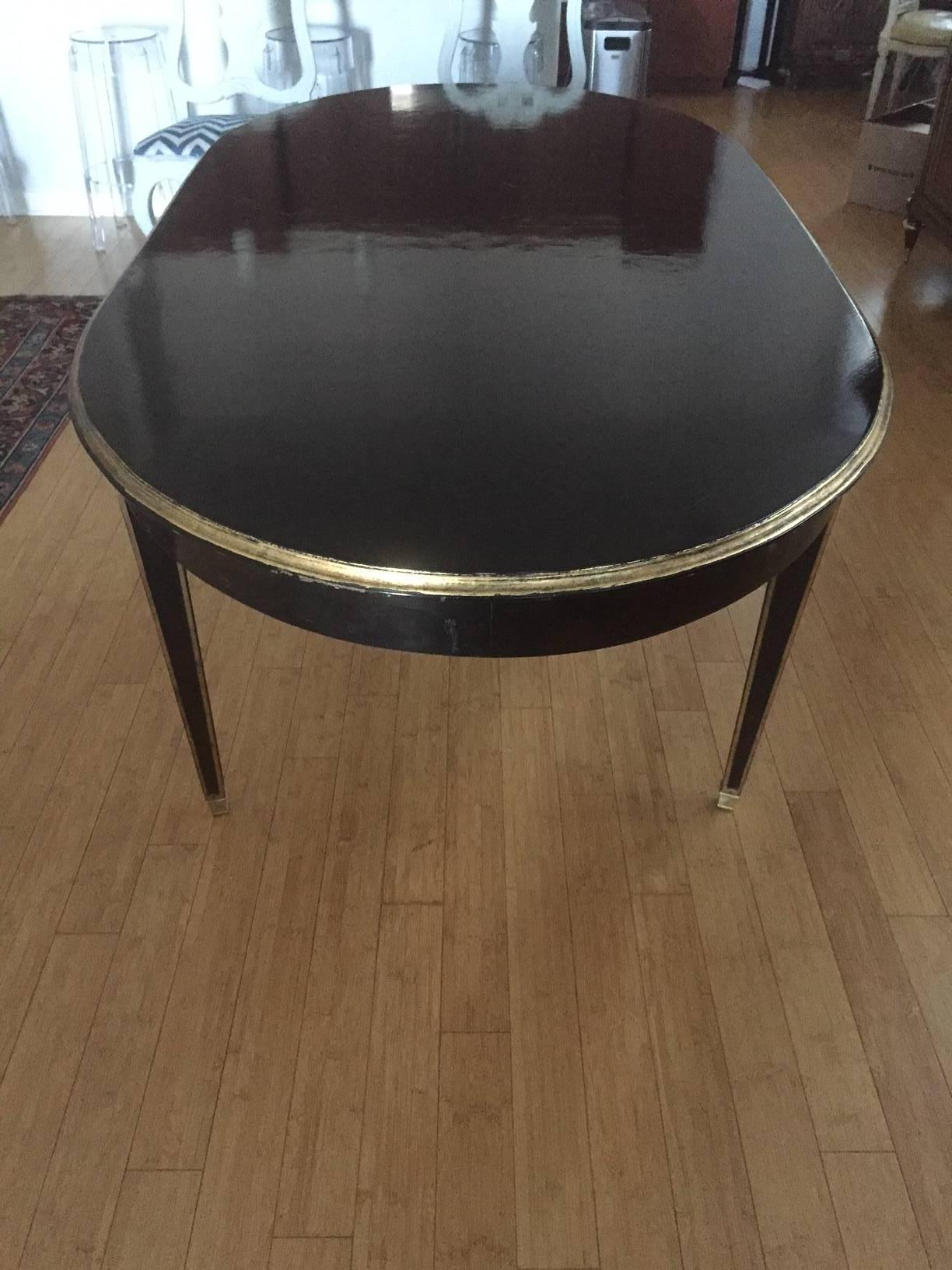 A solid black dining table with no leaves. Wasn't made to accommodate leaves. The space between the legs measures 40