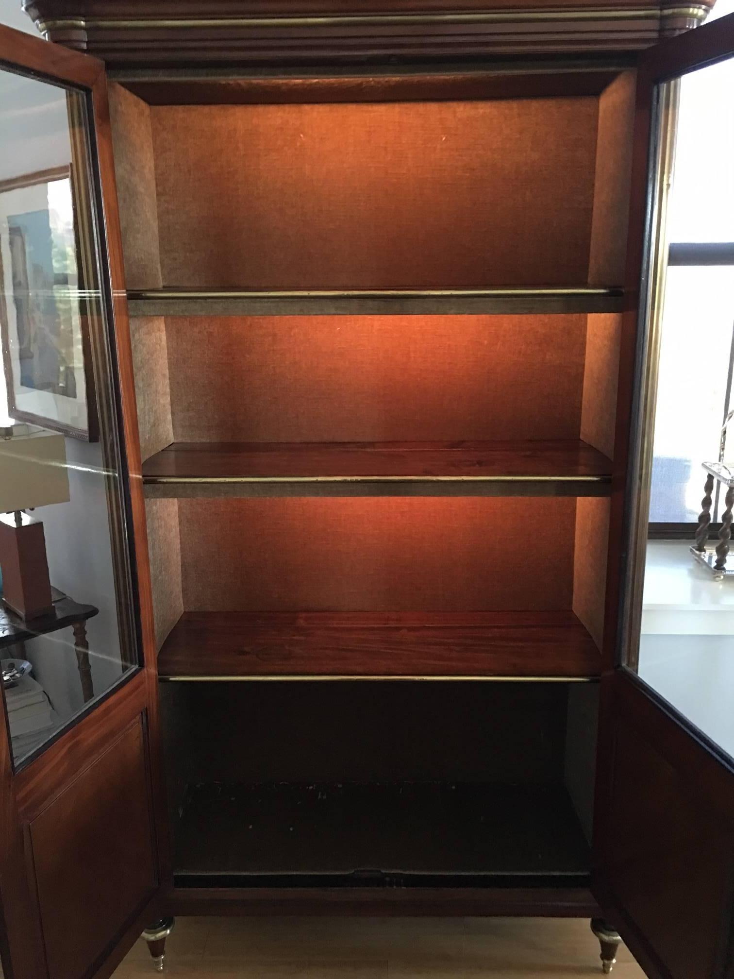 18th century brass molded glazed panel doors enclosing three shelves with later lighting added.