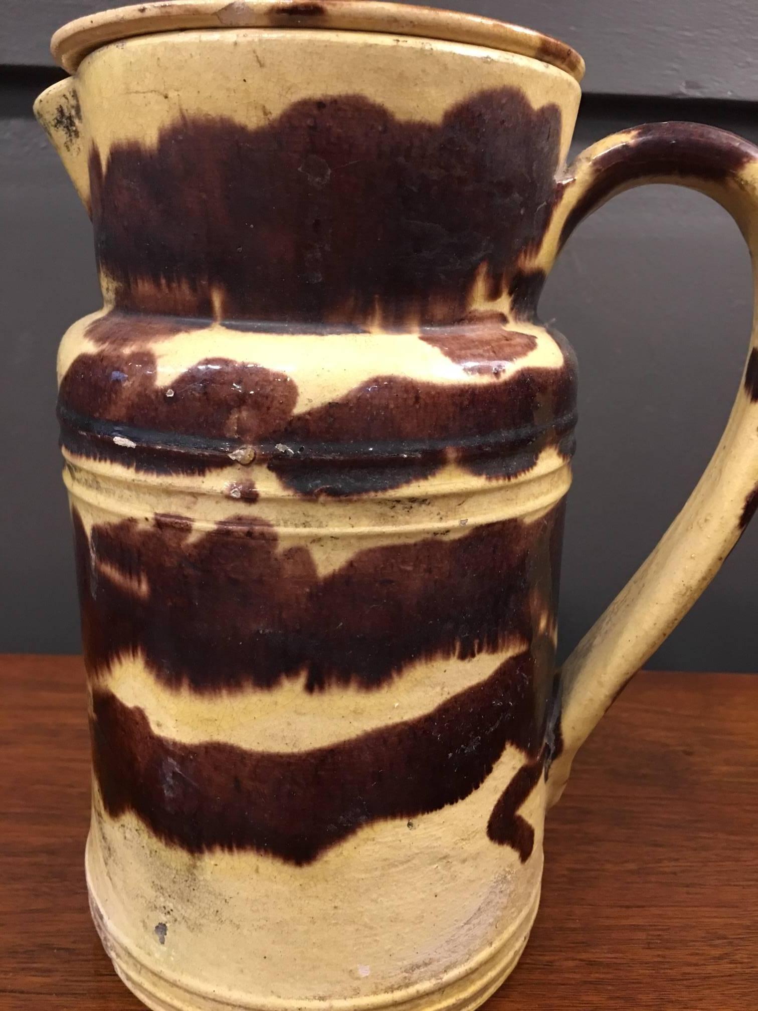 Yellow and brown swirl French pitcher with lid.